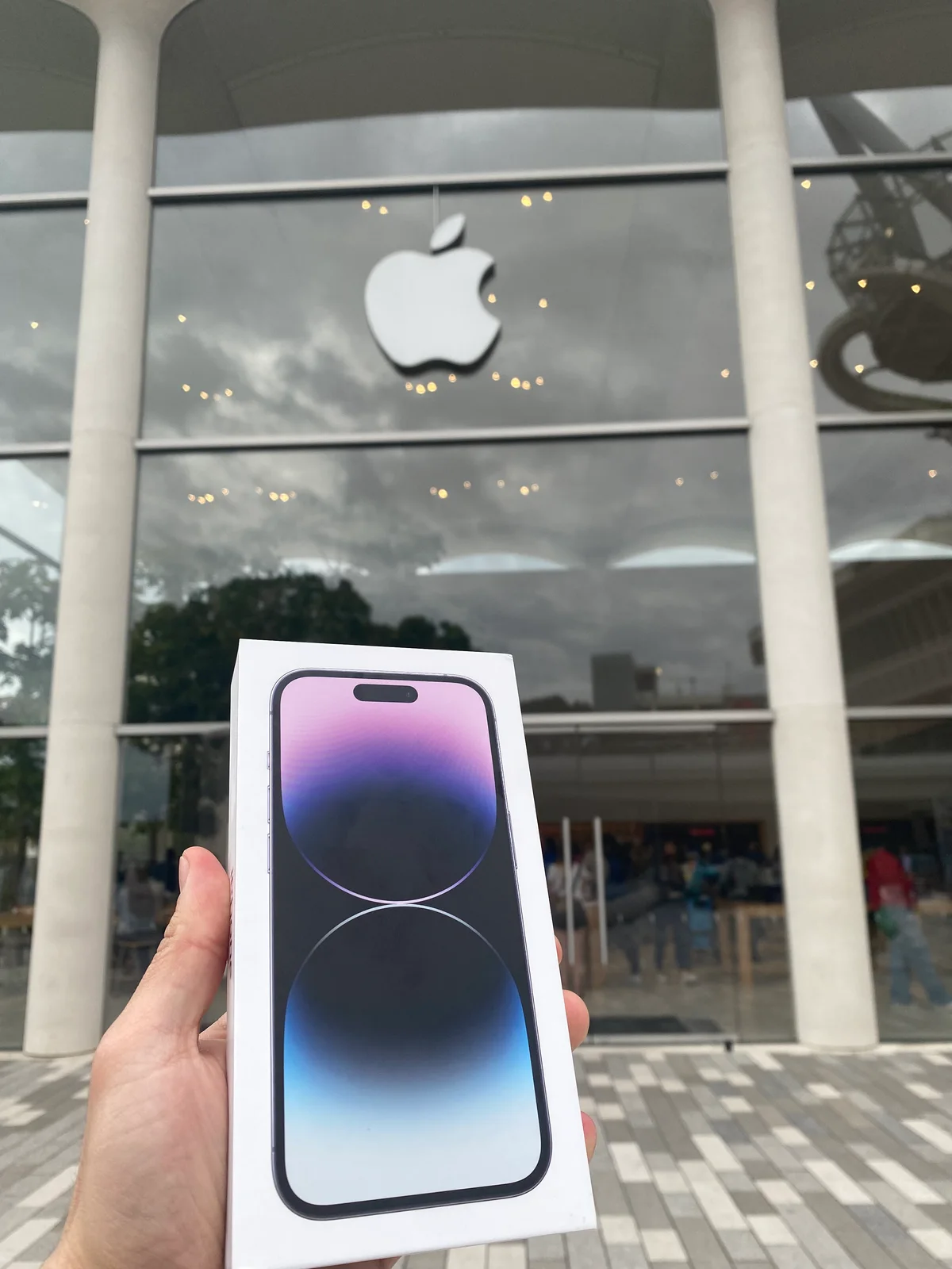 iPhone 14 traído por Spotphone frente a una Apple Store